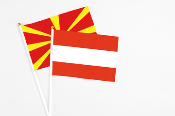 Austria and Macedonia stick flags on white background. High quality fabric, miniature national flag. Peaceful global concept.White floor for copy space.