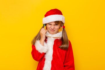 Child in Santa costume making funny faces and putting on party glasses