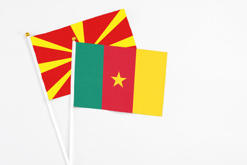 Cameroon and Macedonia stick flags on white background. High quality fabric, miniature national flag. Peaceful global concept.White floor for copy space.