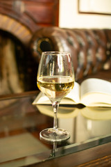 English retro style room with leather chair, open book and glas of white wine