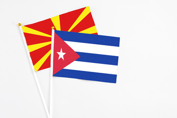 Cuba and Macedonia stick flags on white background. High quality fabric, miniature national flag. Peaceful global concept.White floor for copy space.