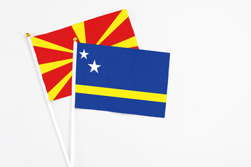 Curacao and Macedonia stick flags on white background. High quality fabric, miniature national flag. Peaceful global concept.White floor for copy space.