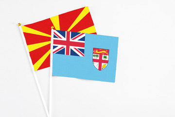 Fiji and Macedonia stick flags on white background. High quality fabric, miniature national flag. Peaceful global concept.White floor for copy space.