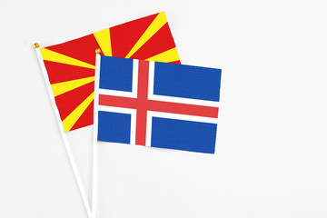 Iceland and Macedonia stick flags on white background. High quality fabric, miniature national flag. Peaceful global concept.White floor for copy space.