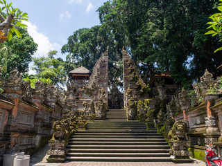 Temple with statues covered with moss on the island of Bali