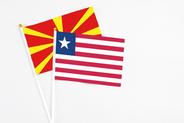 Liberia and Macedonia stick flags on white background. High quality fabric, miniature national flag. Peaceful global concept.White floor for copy space.
