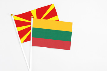 Lithuania and Macedonia stick flags on white background. High quality fabric, miniature national flag. Peaceful global concept.White floor for copy space.
