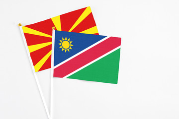 Obraz premium Namibia and Macedonia stick flags on white background. High quality fabric, miniature national flag. Peaceful global concept.White floor for copy space.