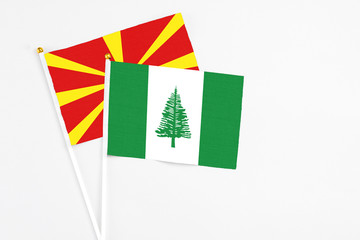 Norfolk Island and Macedonia stick flags on white background. High quality fabric, miniature national flag. Peaceful global concept.White floor for copy space.