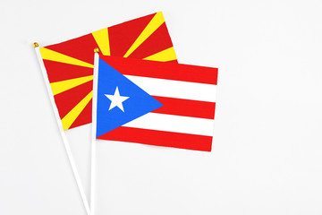 Puerto Rico and Macedonia stick flags on white background. High quality fabric, miniature national flag. Peaceful global concept.White floor for copy space.