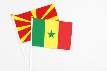 Senegal and Macedonia stick flags on white background. High quality fabric, miniature national flag. Peaceful global concept.White floor for copy space.