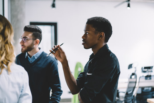 Thoughtful African Business Man Concentrated On Collaboration With Colleagues During Searching And Discussing New Ideas For Management Project, Multicultural Partners Communicate About Proud Ceo