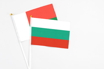 Bulgaria and Madagascar stick flags on white background. High quality fabric, miniature national flag. Peaceful global concept.White floor for copy space.