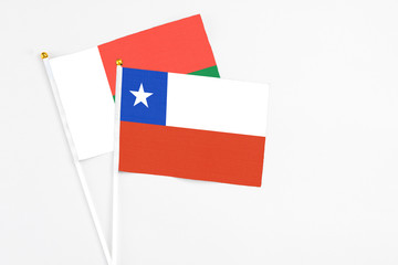 Chile and Madagascar stick flags on white background. High quality fabric, miniature national flag. Peaceful global concept.White floor for copy space.