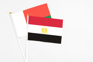 Egypt and Madagascar stick flags on white background. High quality fabric, miniature national flag. Peaceful global concept.White floor for copy space.