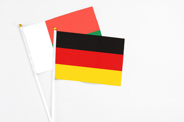 Germany and Madagascar stick flags on white background. High quality fabric, miniature national flag. Peaceful global concept.White floor for copy space.