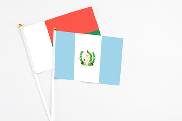 Guatemala and Madagascar stick flags on white background. High quality fabric, miniature national flag. Peaceful global concept.White floor for copy space.