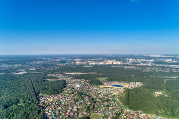 Large green forest. A multi-lane highway runs through the forest. Aerial view, summer sunny day.