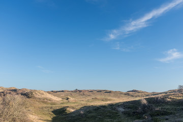Fototapeta na wymiar View over a grassy plateau with a blue sky