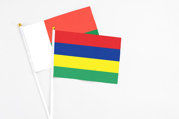 Mauritius and Madagascar stick flags on white background. High quality fabric, miniature national flag. Peaceful global concept.White floor for copy space.