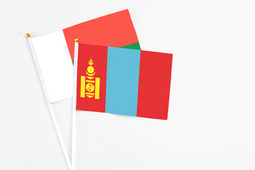 Mongolia and Madagascar stick flags on white background. High quality fabric, miniature national flag. Peaceful global concept.White floor for copy space.