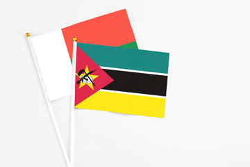 Mozambique and Madagascar stick flags on white background. High quality fabric, miniature national flag. Peaceful global concept.White floor for copy space.