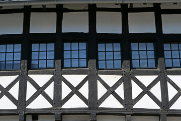 Macro view on six little square windows of a timber framed house with the typical visible brown...