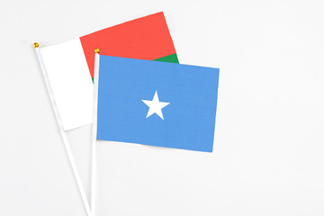 Somalia and Madagascar stick flags on white background. High quality fabric, miniature national flag. Peaceful global concept.White floor for copy space.