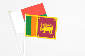 Sri Lanka and Madagascar stick flags on white background. High quality fabric, miniature national flag. Peaceful global concept.White floor for copy space.