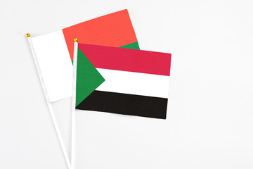 Sudan and Madagascar stick flags on white background. High quality fabric, miniature national flag. Peaceful global concept.White floor for copy space.