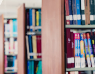 Naklejka premium Picture of blur bookshelf as background in library with copy space. Photo concept of education, knowledge, traditional learning, and literature.