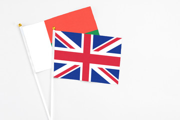United Kingdom and Madagascar stick flags on white background. High quality fabric, miniature national flag. Peaceful global concept.White floor for copy space.