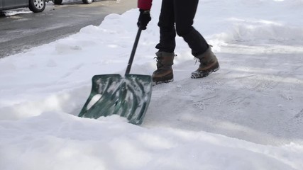Person shoveling snow from driveway.