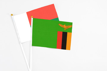 Zambia and Madagascar stick flags on white background. High quality fabric, miniature national flag. Peaceful global concept.White floor for copy space.