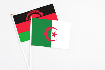 Algeria and Malawi stick flags on white background. High quality fabric, miniature national flag. Peaceful global concept.White floor for copy space.