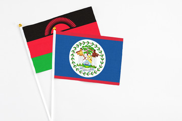 Belize and Malawi stick flags on white background. High quality fabric, miniature national flag. Peaceful global concept.White floor for copy space.