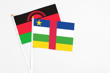 Central African Republic and Malawi stick flags on white background. High quality fabric, miniature national flag. Peaceful global concept.White floor for copy space.
