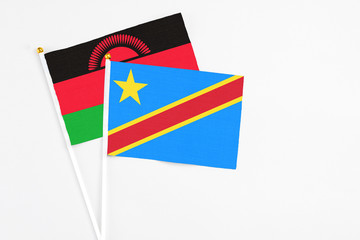 Congo and Malawi stick flags on white background. High quality fabric, miniature national flag. Peaceful global concept.White floor for copy space.