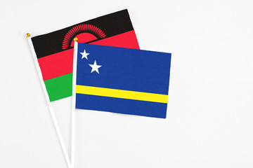 Curacao and Malawi stick flags on white background. High quality fabric, miniature national flag. Peaceful global concept.White floor for copy space.