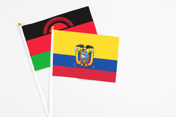 Ecuador and Malawi stick flags on white background. High quality fabric, miniature national flag. Peaceful global concept.White floor for copy space.