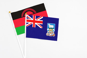 Falkland Islands and Malawi stick flags on white background. High quality fabric, miniature national flag. Peaceful global concept.White floor for copy space.