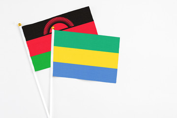 Gabon and Malawi stick flags on white background. High quality fabric, miniature national flag....