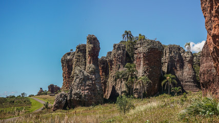 Fototapeta na wymiar Sandstone geological monuments (Arenitos) in Vila Velha State Park, with local road on background - Ponta Grossa, Paraná, Brazil