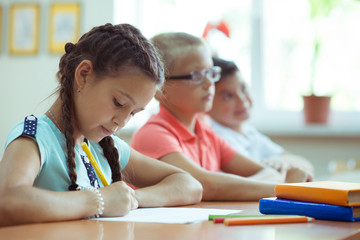 Happy clever children learning in classroom