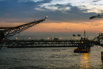 Fototapeta premium Silhouette of oil production platform during sunset