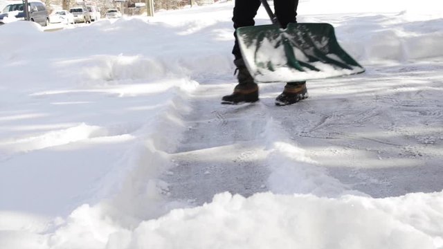 Person Shoveling Snow From Driveway.