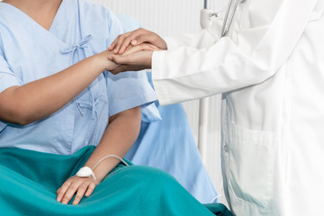 The doctor hold hands patient to encourage To fight the disease And cheer to receive treatment, to health care concept.