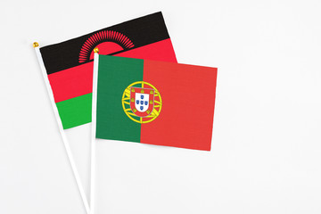 Portugal and Malawi stick flags on white background. High quality fabric, miniature national flag. Peaceful global concept.White floor for copy space.