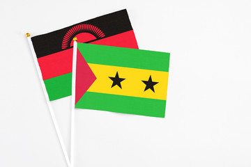 Sao Tome And Principe and Malawi stick flags on white background. High quality fabric, miniature national flag. Peaceful global concept.White floor for copy space.
