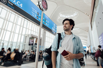 The guy at the airport waiting for departure, looking schedule.